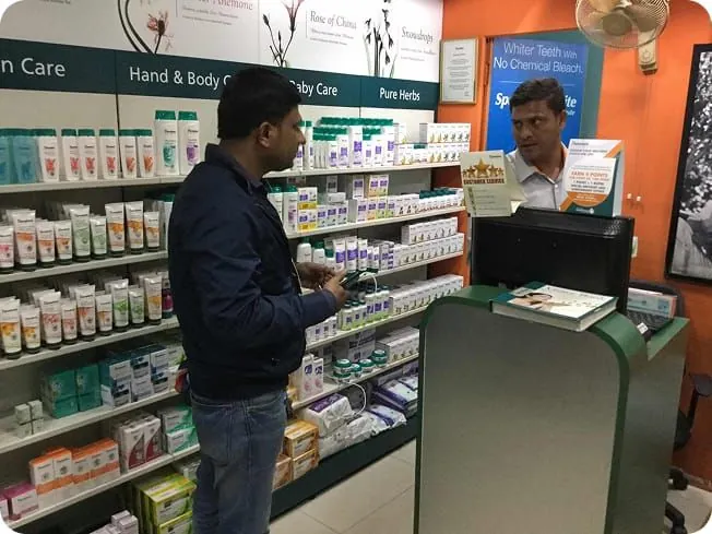 A customer browsing densely stocked Himalaya Wellness shelves with no guidance